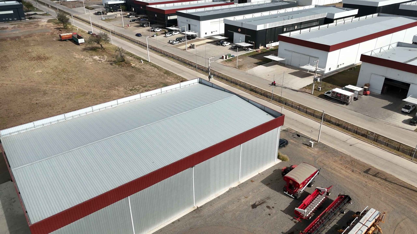 Vista aérea de una nave industrial terminada en un parque industrial, con el portón corredizo abierto