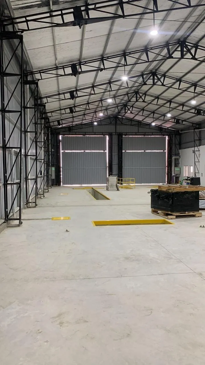 Interior de nave con pórticos reticulados y cerramiento de chapa colocado