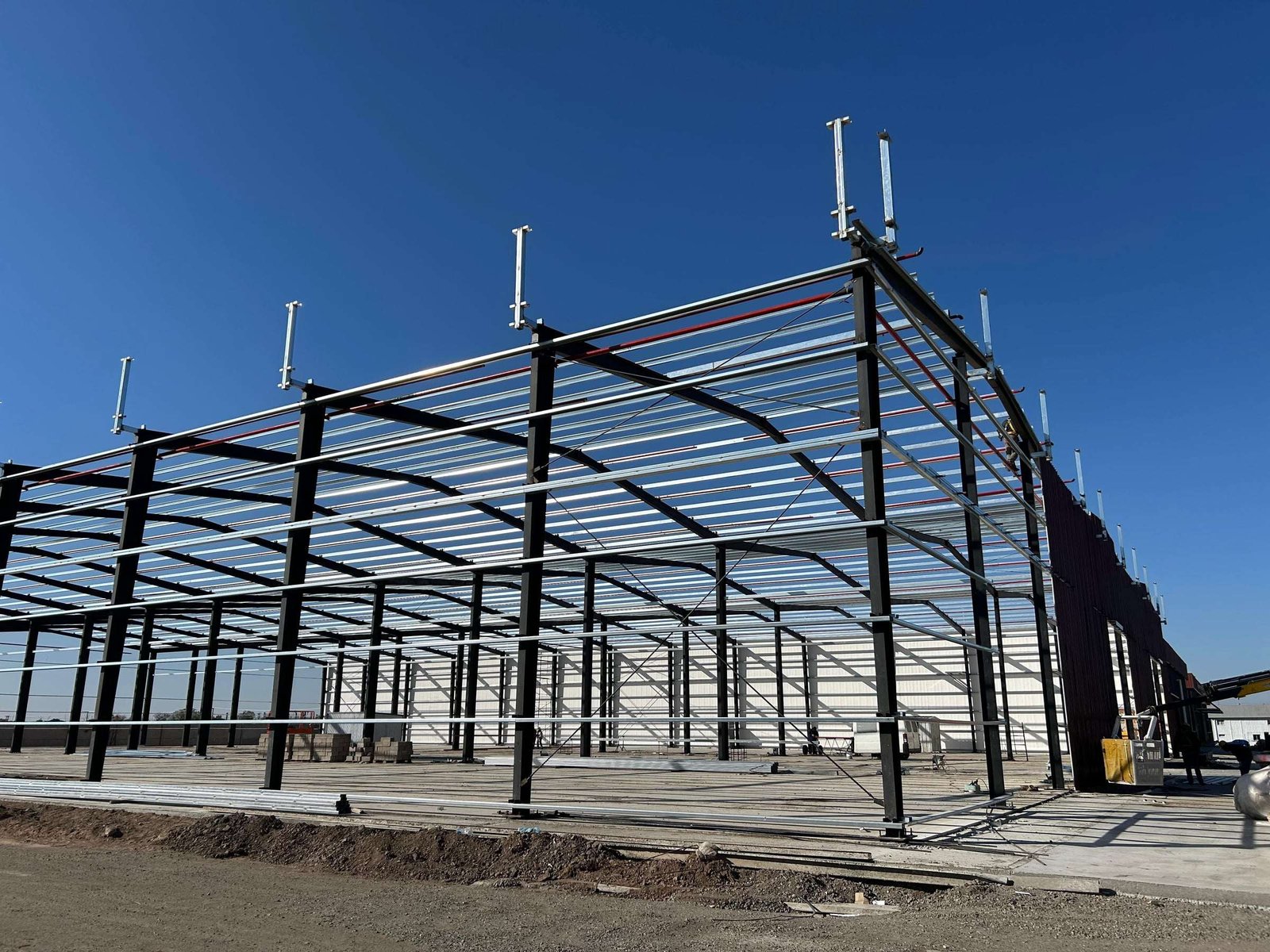 Nave industrial metálica durante el montaje de correas y cerramientos