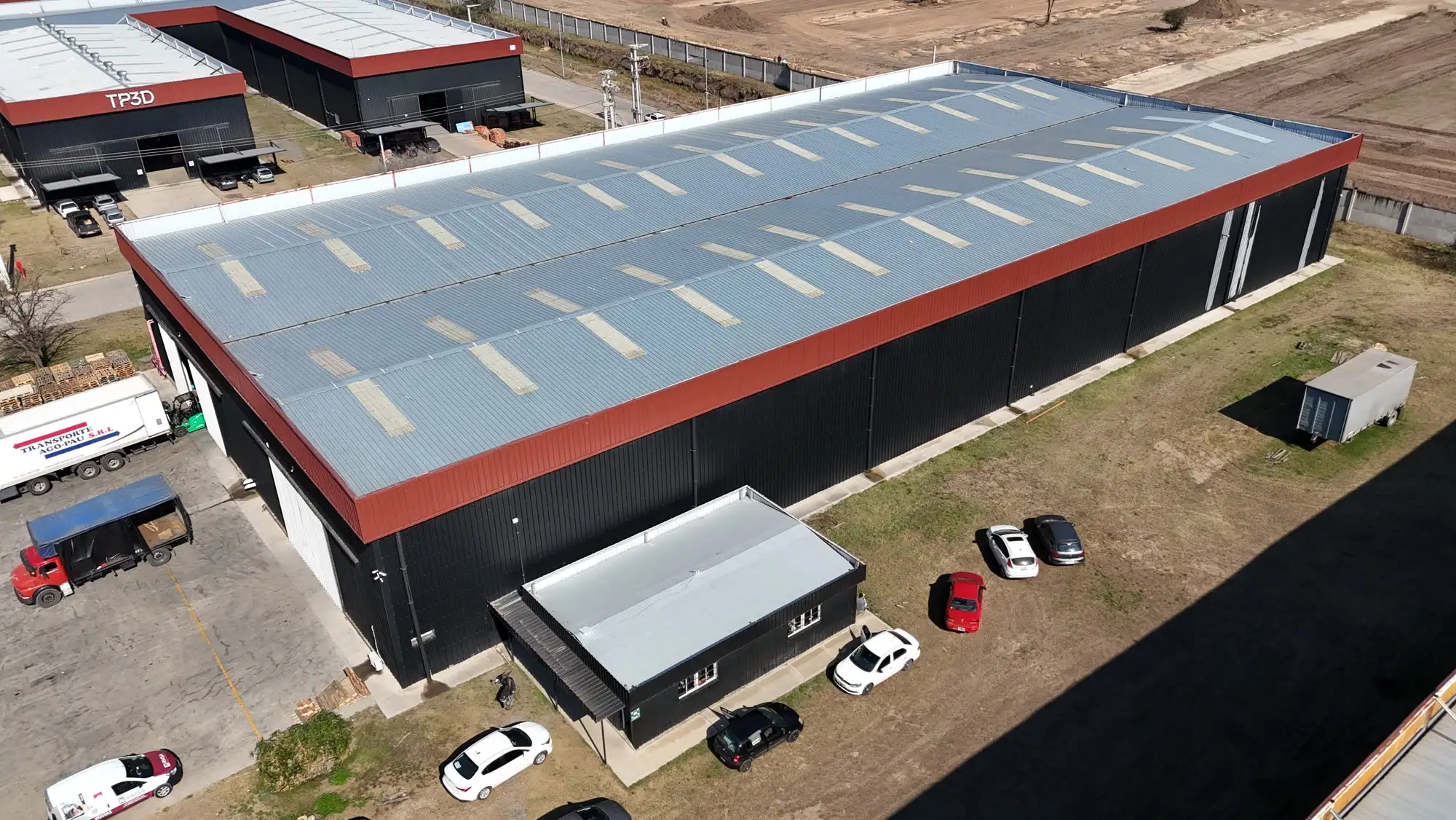 Nave industrial terminada con playa de maniobras de hormigón y camión en posición de carga