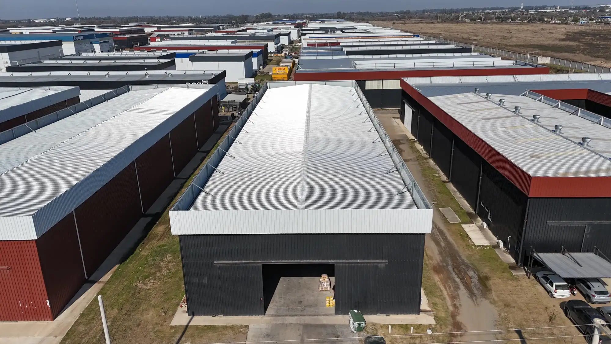 Nave industrial terminada con portón de gran altura abierto en la fachada