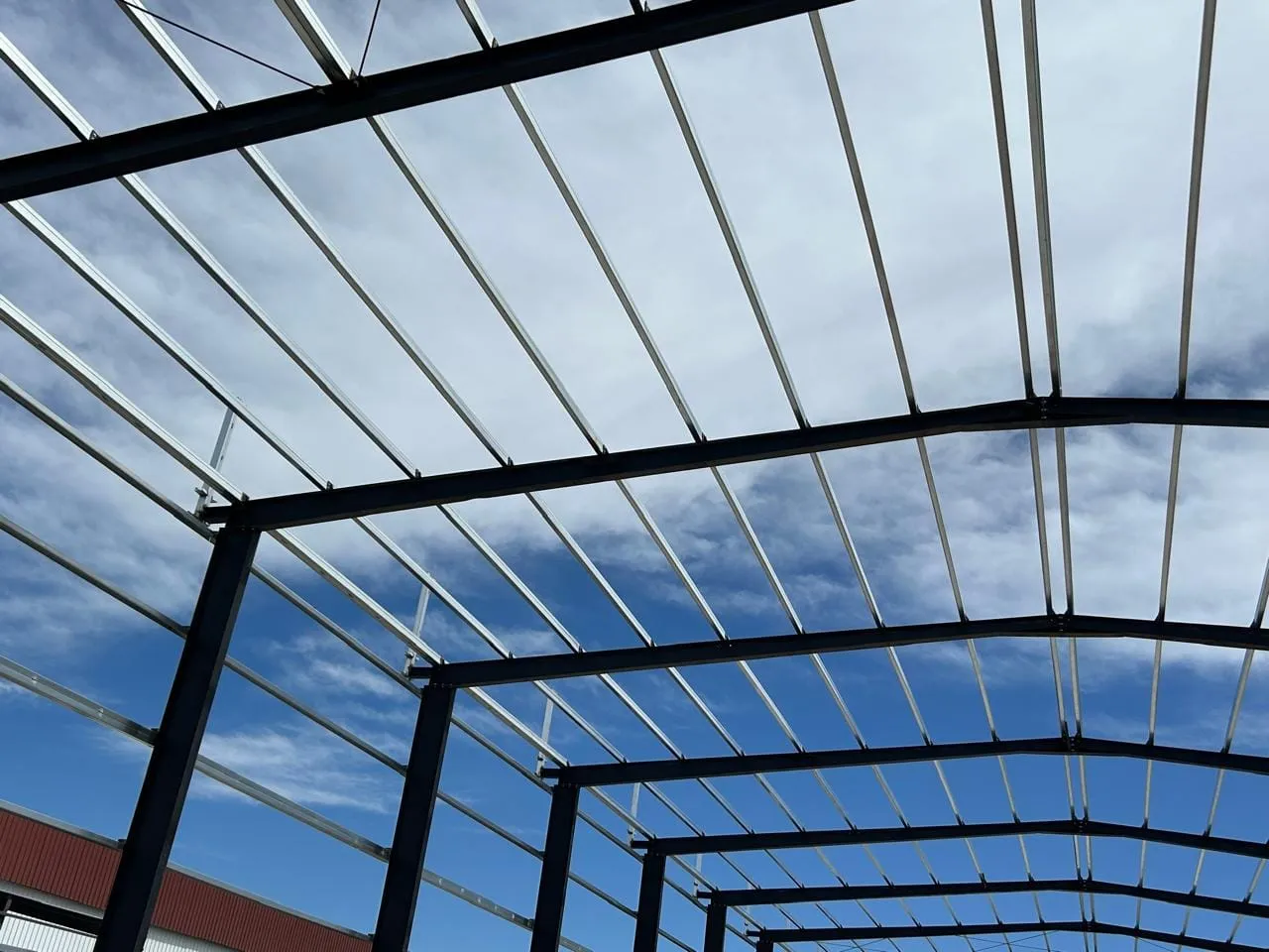 Estructura de nave a dos aguas vista desde el interior, con correas y tensores de arriostramiento